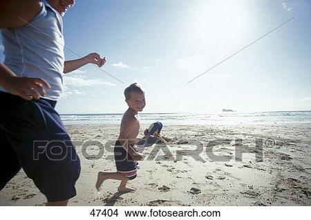 Side profile of two boys running on beach View Large Photo Image Picture - Side profile of two boys running on beach . Fotosearch