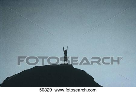 Stock Photo - Silhouette of man on top of summit . Fotosearch