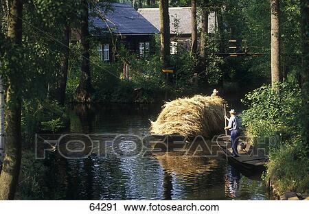 Stock Image - Straw loaded on boat in canal, Spreewald, Brandenburg, Germany . Fotosearch