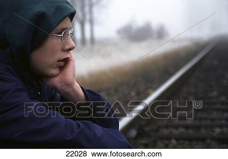 Stock Photo - Teenager sitting on rails . Fotosearch