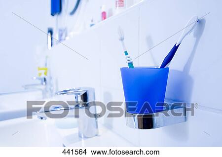 Picture - Toothbrushes in toothbrush holding at washbasin . Fotosearch