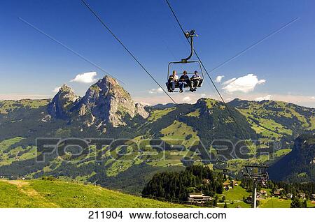 Tourists on ski lifts at mountainous landscape, Switzerland View Large Photo Image Picture - Tourists on ski lifts at mountainous landscape, Switzerland . Fotosearch