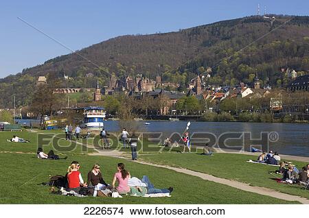Picture - Tourists relaxing on riverside, Heidelberg, Germany . Fotosearch