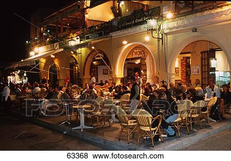 Tourists sitting at outdoor cafe, Dodecanese Islands, Ionian Islands, Rhodes, Greece View Large Photo Image Stock Photo - Tourists sitting at outdoor cafe, Dodecanese Islands, Ionian Islands, Rhodes, Greece . Fotosearch