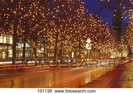 Trees lit up with Christmas lights along road at night, Berlin, Germany View Large Photo Image Stock Photo - Trees lit up with Christmas lights along road at night, Berlin, Germany . Fotosearch