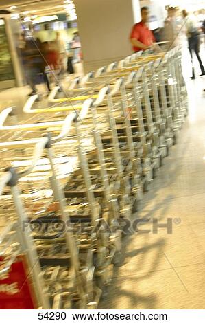 Trolleys in row at airport View Large Photo Image Stock Image - Trolleys in row at airport . Fotosearch