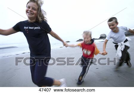 Two boys and girl playing on the beach View Large Photo Image Stock Photo - Two boys and girl playing on the beach . Fotosearch