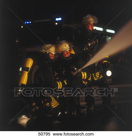 Two firemen spraying water on fire with hose View Large Photo Image Stock Photography - Two firemen spraying water on fire with hose . Fotosearch