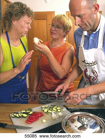 Two women and man preparing food in kitchen View Large Photo Image Stock Photography - Two women and man preparing food in kitchen . Fotosearch