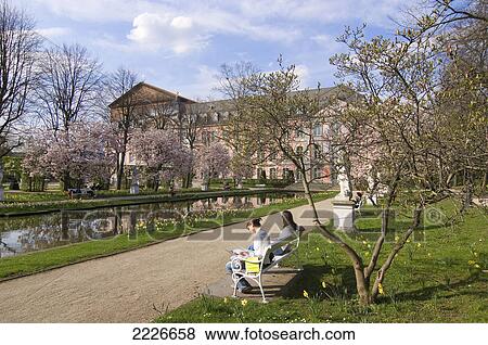 Two women sitting on bench near pool in front of palace, Kurfuerstliches Palais, Trier, Germany View Large Photo Image Stock Photo - Two women sitting on bench near pool in front of palace, Kurfuerstliches Palais, Trier, Germany . Fotosearch