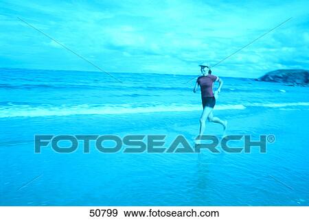 Stock Photo - Woman jogging on beach . Fotosearch