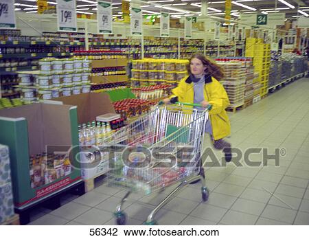 Woman running with a trolley in a supermarket View Large Photo Image Stock Image - Woman running with a trolley in a supermarket . Fotosearch