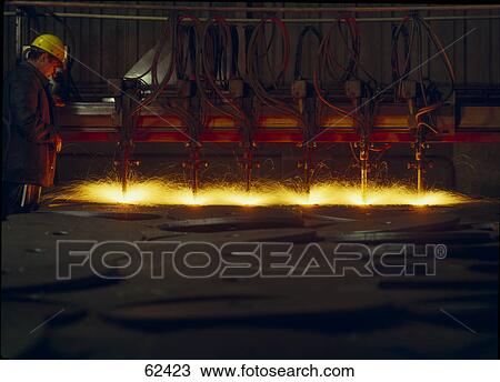 Worker operating machine drilling metal in factory View Large Photo Image Stock Image - Worker operating machine drilling metal in factory . Fotosearch