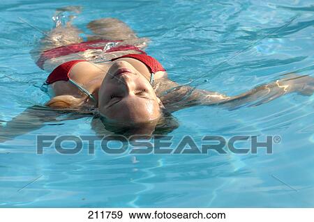 Young woman drifting in swimming pool View Large Photo Image Stock Photo - Young woman drifting in swimming pool . Fotosearch