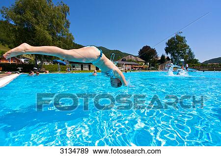 Stock Photo - Young woman jumping in a pool, side view . Fotosearch