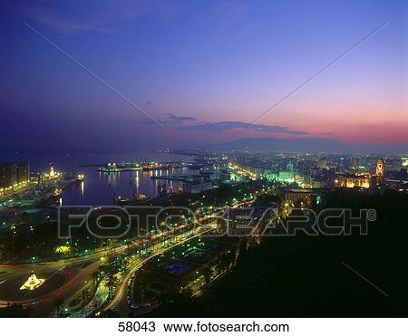 Aerial view of a city lit up at dusk View Large Photo Image Stock Image - Aerial view of a city lit up at dusk . Fotosearch