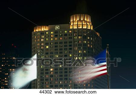 Stock Image - American flag in front of hotel at night, Sheraton Hotel, Chicago, Illinois, USA . Fotosearch