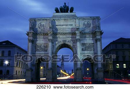 Stock Image - Archway monument in city against dusky sky . Fotosearch