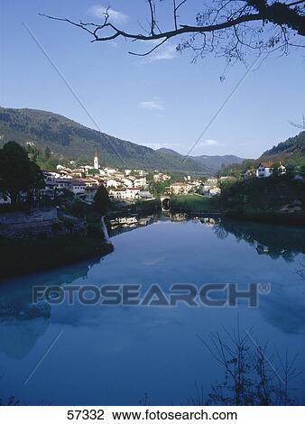 Stock Image - Blue sky and town reflected in the river, Soca River, Soca, Slovenia . Fotosearch