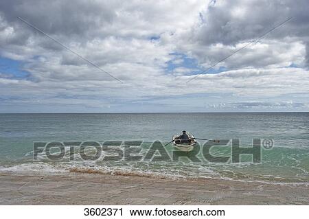 Stock Image - Boat is being pulled on the beach, Burgau, Algarve, Portugal . Fotosearch