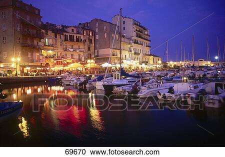 Stock Image - Boats moored at harbor at night, Bastia, Corsica, France . Fotosearch