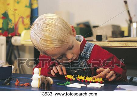 Boy playing with a model train set View Large Photo Image Stock Image - Boy playing with a model train set . Fotosearch