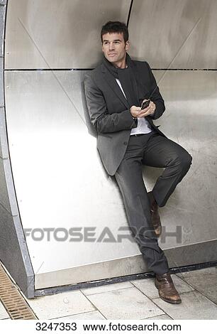 Businessman using mobile phone, full-length View Large Photo Image Stock Image - Businessman using mobile phone, full-length . Fotosearch