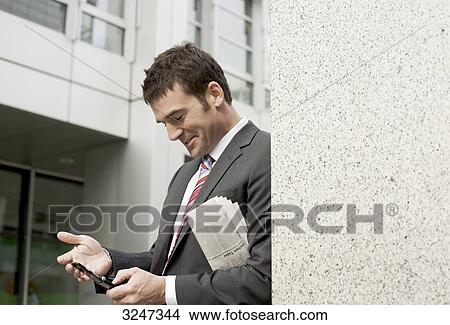 Businessman using mobile phone, waist up View Large Photo Image Picture - Businessman using mobile phone, waist up . Fotosearch
