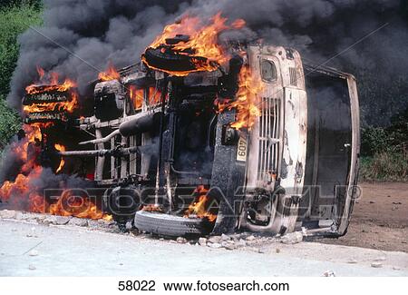 Stock Image - Car burning on road . Fotosearch