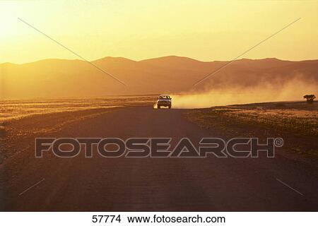 Car moving on a countryroad leaving a trail of dust View Large Photo Image Picture - Car moving on a countryroad leaving a trail of dust . Fotosearch
