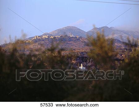 Stock Image - Church on a landscape viewed through plants, Peloponnesus, Greece . Fotosearch