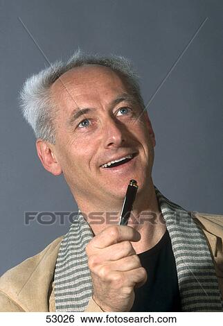 Stock Photograph - Close-up of man holding pen and smiling . Fotosearch