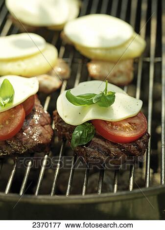 Close-up of pieces of meat and slices of tomatoes on barbecue grill View Large Photo Image Stock Photo - Close-up of pieces of meat and slices of tomatoes on barbecue grill . Fotosearch