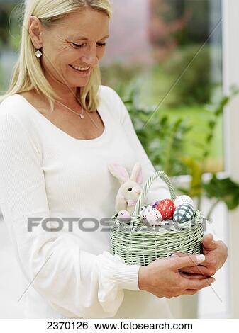 Close-up of woman carrying basket of Easter eggs View Large Photo Image Stock Photograph - Close-up of woman carrying basket of Easter eggs . Fotosearch