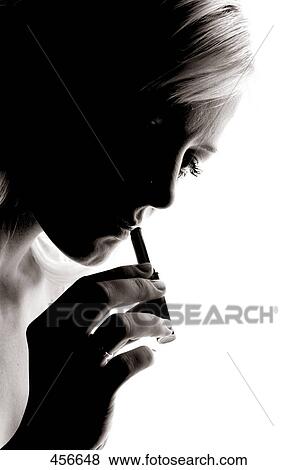 Close-up of young woman applying lipstick View Large Photo Image Stock Photo - Close-up of young woman applying lipstick . Fotosearch