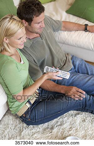 Stock Image - Couple at home watching TV . Fotosearch