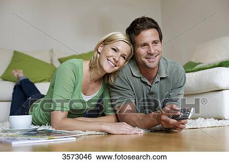 Couple at home watching TV View Large Photo Image Stock Photograph - Couple at home watching TV . Fotosearch