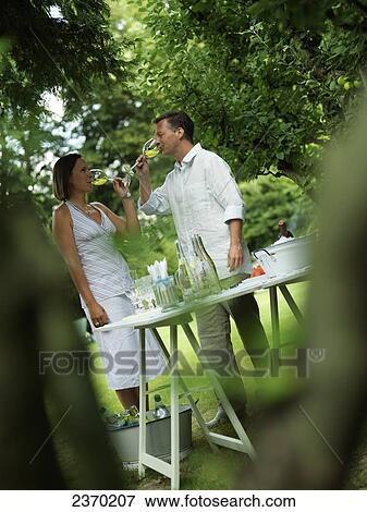 Stock Photo - Couple drinking wine in garden . Fotosearch