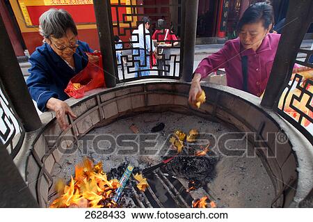 Devotees making religious offerings at Buddhist temple View Large Photo Image Stock Image - Devotees making religious offerings at Buddhist temple . Fotosearch
