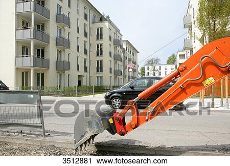 Stock Image - Digger at residential neighborhood in Munich, Germany . Fotosearch