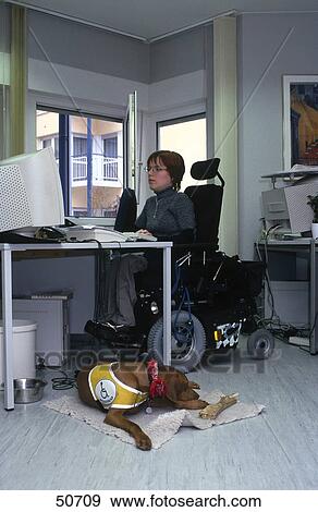 Dog lying in front of handicapped woman working on computer View Large Photo Image Stock Photo - Dog lying in front of handicapped woman working on computer . Fotosearch