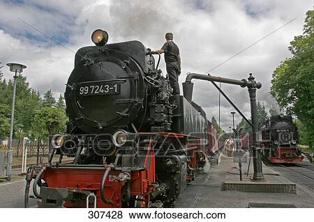 Driver standing on engine at railway station View Large Photo Image Stock Photo - Driver standing on engine at railway station . Fotosearch