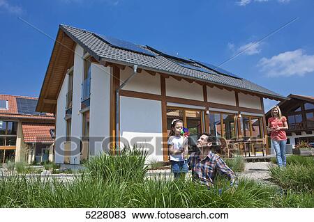 Stock Image - Family in front of Lehner energy house, Poing, Bavaria, Germany, Europe . Fotosearch