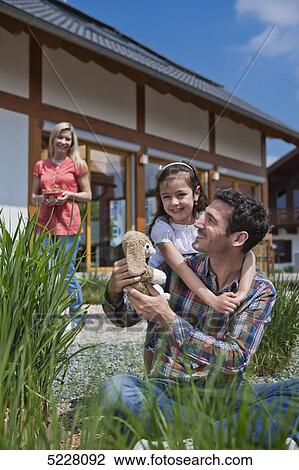 Stock Image - Family in front of Lehner energy house, Poing, Bavaria, Germany, Europe . Fotosearch