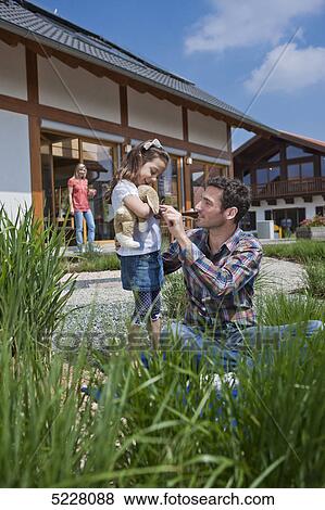 Stock Photo - Family in front of Lehner energy house, Poing, Bavaria, Germany, Europe . Fotosearch