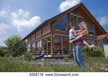 Stock Photo - Family in front of Lehner energy house, Poing, Bavaria, Germany, Europe . Fotosearch