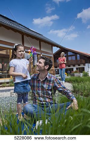 Stock Photograph - Family in front of Lehner energy house, Poing, Bavaria, Germany, Europe . Fotosearch