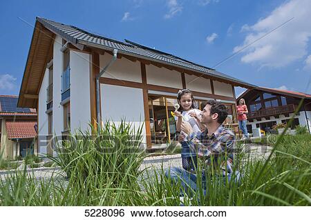 Stock Photograph - Family in front of Lehner energy house, Poing, Bavaria, Germany, Europe . Fotosearch