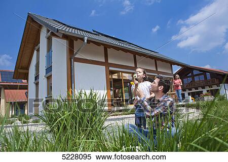 Stock Photography - Family in front of Lehner energy house, Poing, Bavaria, Germany, Europe . Fotosearch