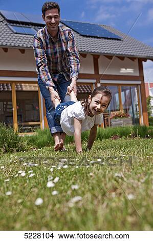 Picture - Father with daughter in front of Lehner energy house, Poing, Bavaria, Germany, Europe . Fotosearch